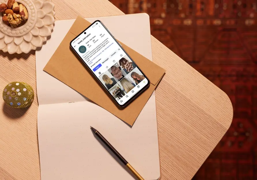 Smartphone sul tavolo che mostra il profilo instagram di Testè Hair Salon
